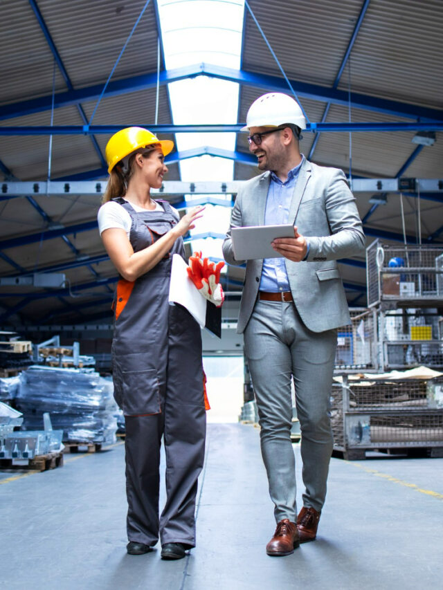 cropped-manager-supervisor-and-industrial-worker-in-uniform-walking-in-large-metal-factory-hall-and-talking-about-increasing-production.jpg